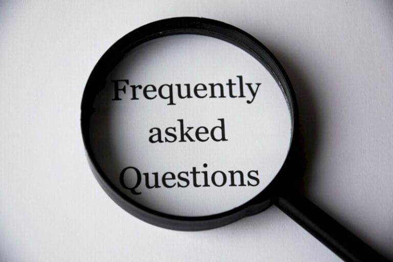 It’s a good idea to answer common questions on your website. Frequently asked questions under a magnifying glass.