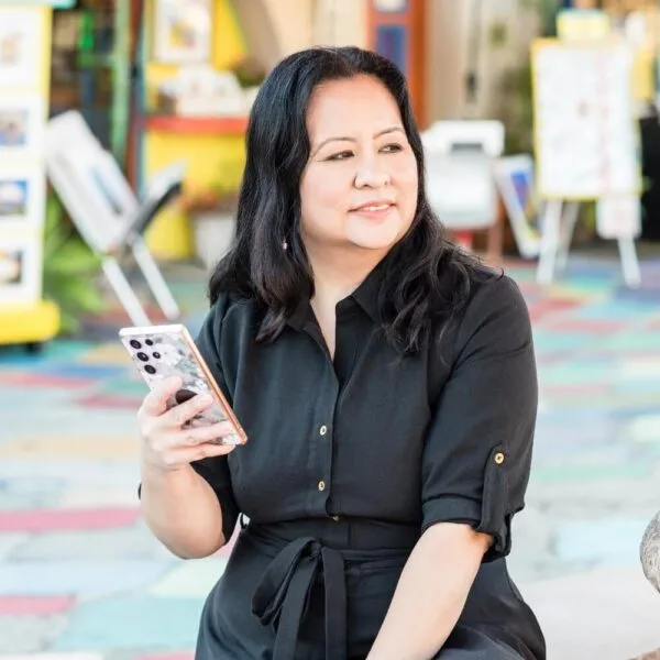 Frances on her cellphone looking right and smiling